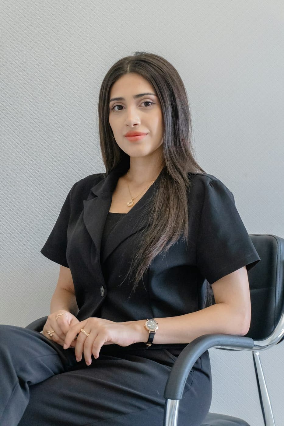 Leila Haddad, seated, photographed against a pale studio wall